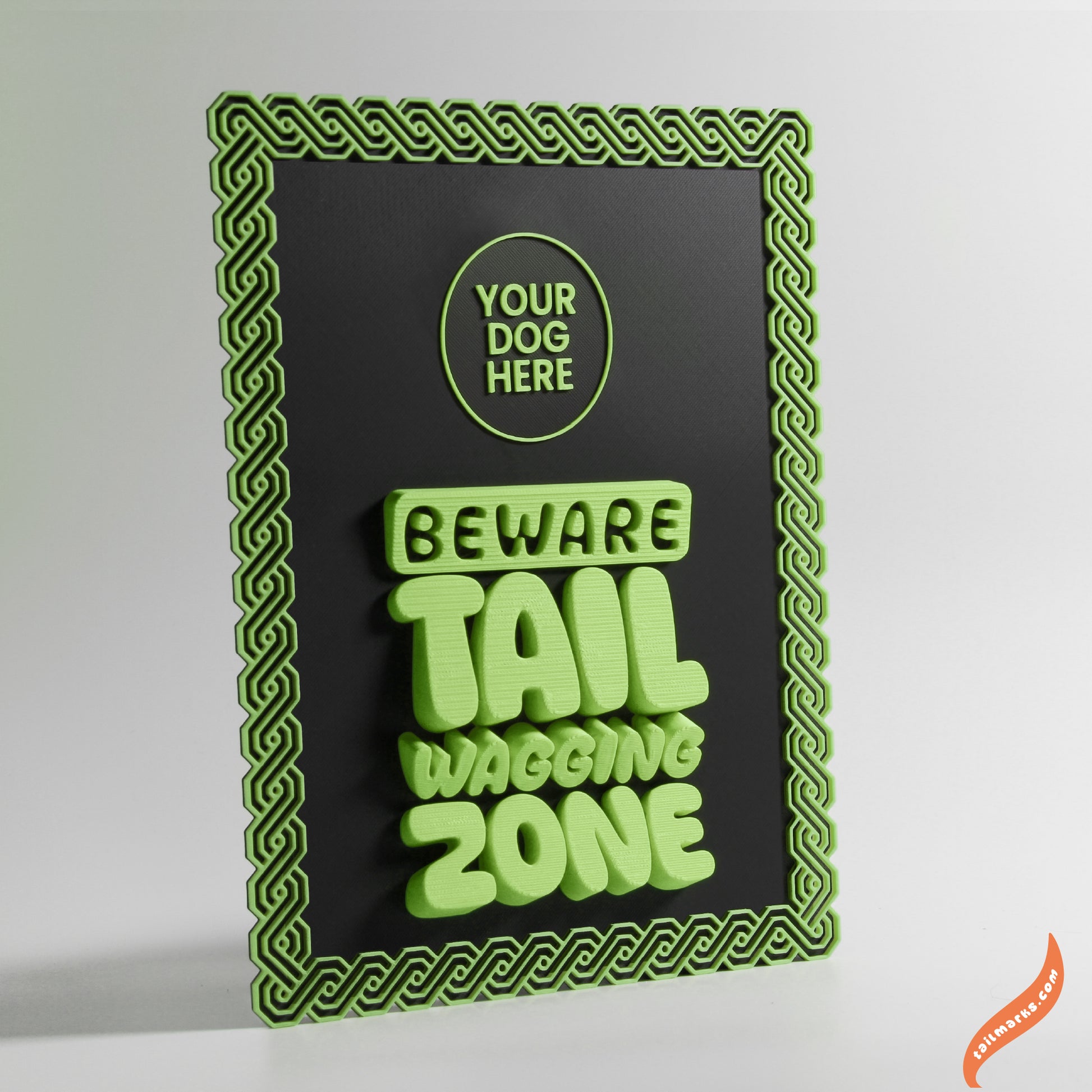 Decorative sign with green text 'Beware Tail Waving Zone' and a maya green frame on a black background.