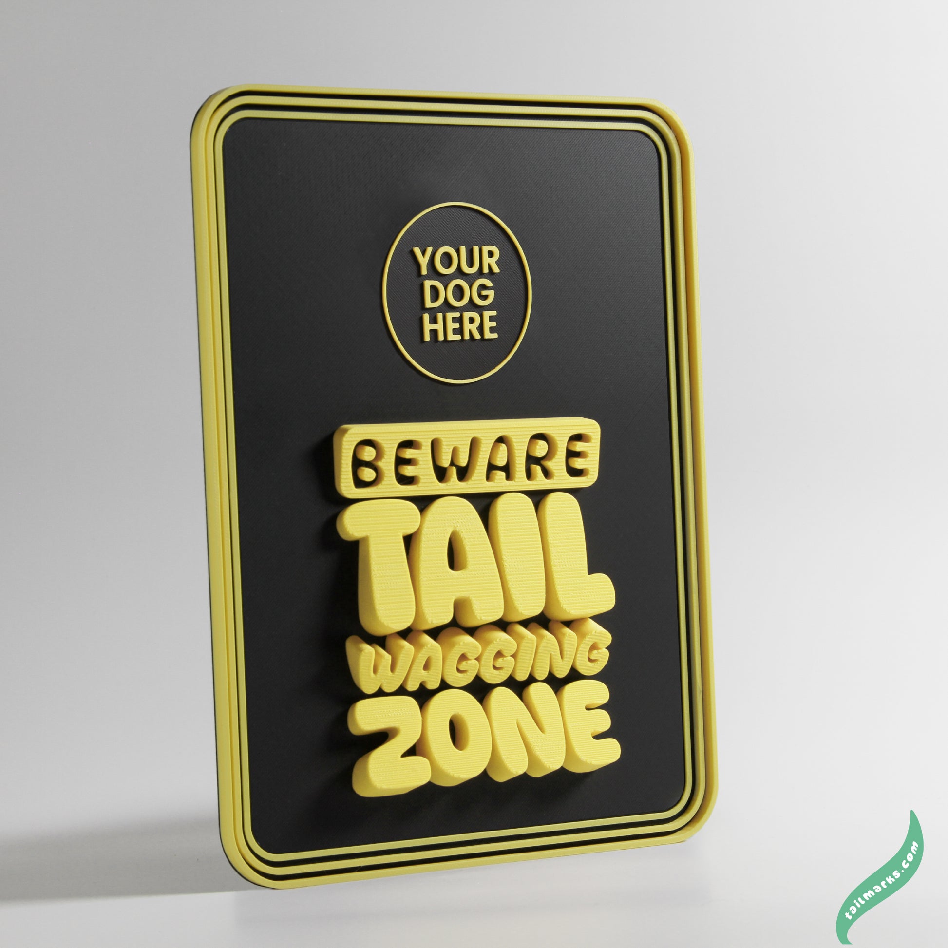 Black and yellow sign with text 'Beware Tail Wagging Zone' on a white background with a round yellow frame