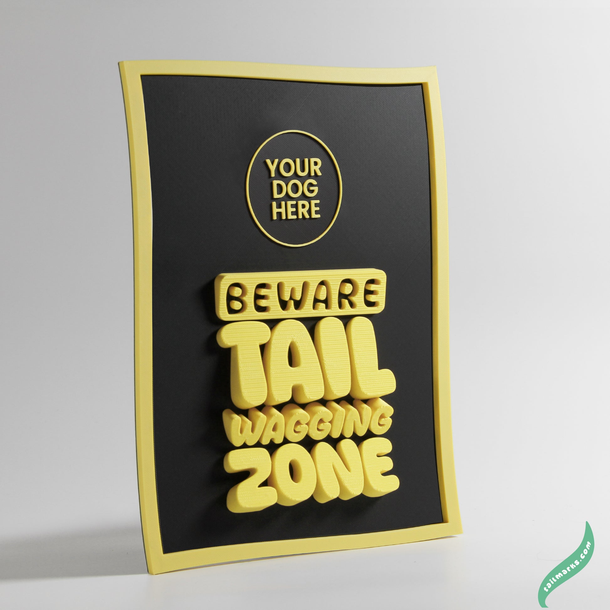Black and yellow sign with text 'Beware Tail Wagging Zone' a waggy frame on a gray background